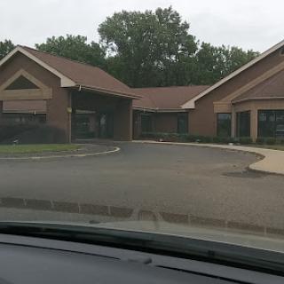A view of a commercial building from a parked car, showcasing its architectural design and surrounding landscape.