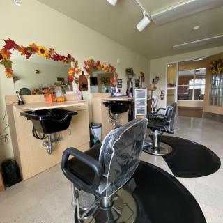 A cozy hair salon with autumn-themed decor and multiple styling stations.