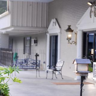 A serene front porch setting with chairs and decorative lighting.