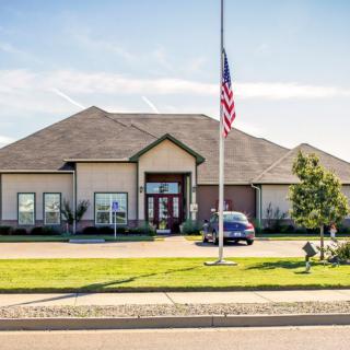 A suburban house with a manicured lawn and an American flag in front.