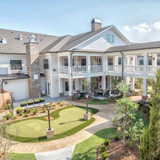 A spacious residential building with a landscaped yard and modern architecture.
