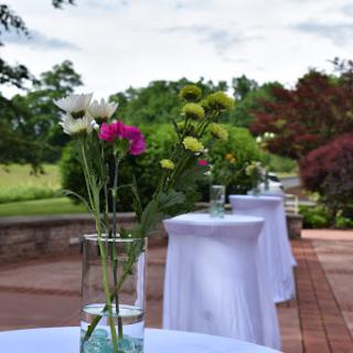 An elegant outdoor setup featuring tables adorned with floral arrangements, perfect for a special event.