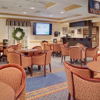 An inviting indoor seating area with a bar and television set, featuring tables and chairs arranged for dining or social gatherings.