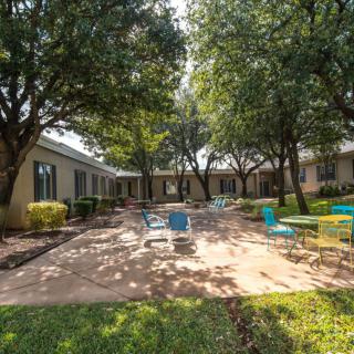 A serene courtyard with outdoor seating and lush greenery.