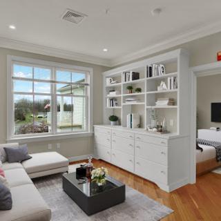 A beautifully designed living room featuring modern furniture, ample natural light, and stylish shelving.