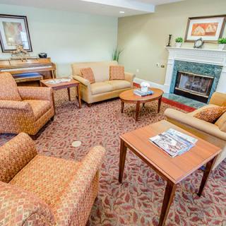 A cozy living room with sofas, armchairs, and a fireplace.