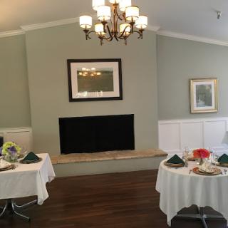 A beautifully arranged dining area featuring elegant tables, a chandelier, and tasteful wall decorations.