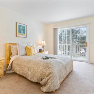 A cozy bedroom with modern decor and a large window allowing natural light.