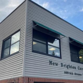 A corner view of a commercial building with 'New Brighton' signage on the exterior.