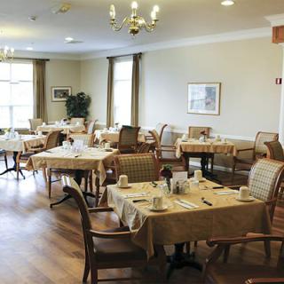 An elegant dining room set with tables and chairs, ready for guests.