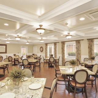 A spacious and elegantly decorated dining room with neatly arranged tables and chairs.