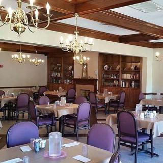 An elegant dining room with chandeliers and neatly arranged tables and chairs.