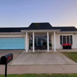 A suburban house with a two-car garage and a front porch supported by columns.