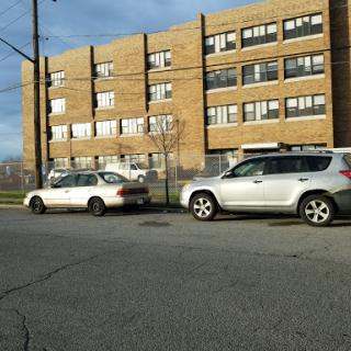 A view of parked cars in front of a brick building.