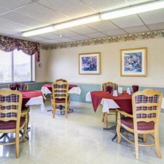 A small dining area with tables set for service, featuring a simple yet cozy decor.
