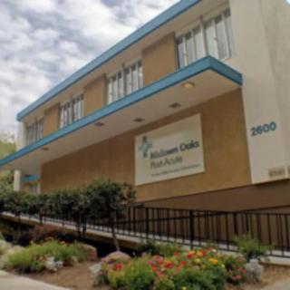 A photo of the exterior of a health center building with landscaped surroundings.