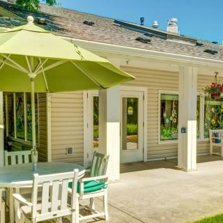 A sunny backyard patio with an umbrella and outdoor furniture.