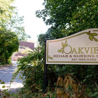 Entrance sign for Oakview Rehab & Nursing Center surrounded by lush greenery.
