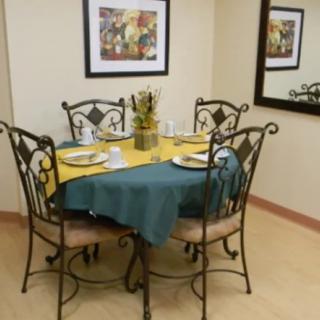 A cozy dining area with a set table and elegant wrought iron chairs.