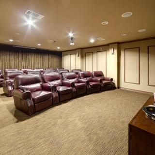 A luxurious home theater with leather seating arranged in rows.