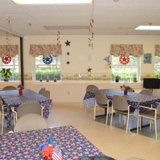 A community dining area decorated with a patriotic theme, featuring tables and chairs.
