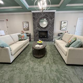 A modern living room with two beige sofas facing each other, a central coffee table, and a stylish fireplace.