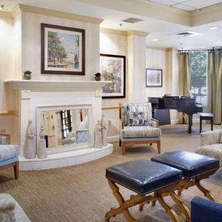 A cozy living room with a fireplace, comfortable seating, and elegant artwork.