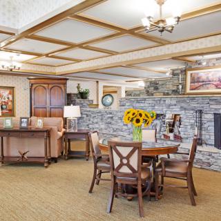 A cozy living room with a stone fireplace and a dining table adorned with sunflowers.