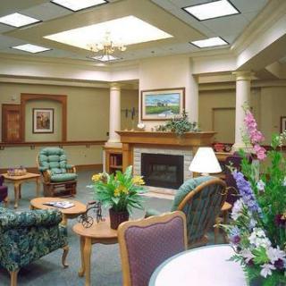 A cozy lounge area featuring comfortable seating, a fireplace, and decorative plants.
