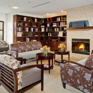 A cozy living room with a fireplace, bookshelves, and comfortable seating.