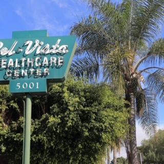 Sign for Sol Vista Healthcare Center surrounded by trees.
