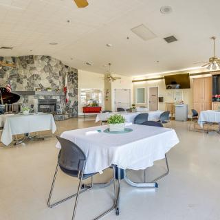 A modern dining area with neatly arranged tables and chairs, decorated with plants and wall art.