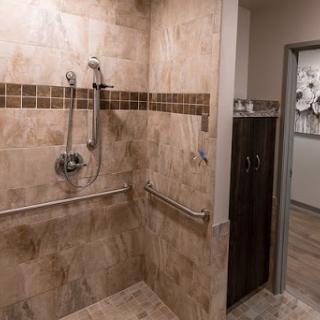 A spacious and modern accessible shower featuring elegant tile work.
