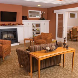 A cozy living room with a fireplace, comfortable seating, and warm-toned decor.