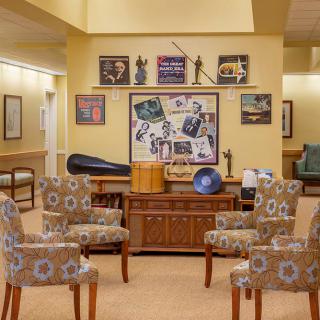 A cozy seating area with patterned chairs and a display of wall art.