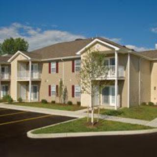 A suburban apartment building with balconies and manicured landscaping.