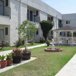 A courtyard within an apartment complex featuring a garden and a gazebo.