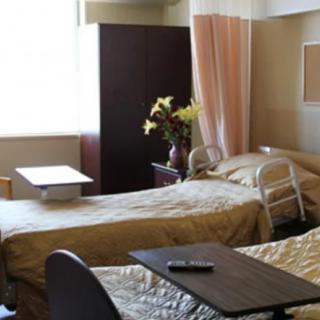 A cozy hospital room with two beds separated by a privacy curtain.
