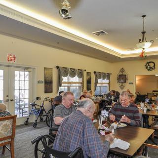 A group of seniors enjoying a meal together in a dining room setting.