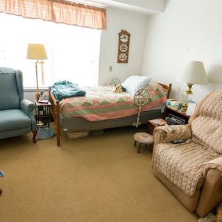 A cozy bedroom with comfortable chairs and a neatly made bed.
