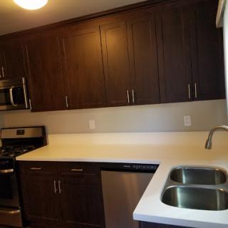 A modern kitchen featuring dark cabinetry and stainless steel appliances.