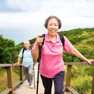 Elderly couple hiking on a scenic trail.