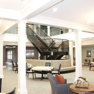 A spacious lobby with a central staircase and seating area.