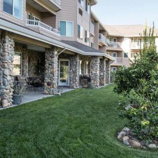 Exterior view of a residential building with stone columns and landscaped lawn.
