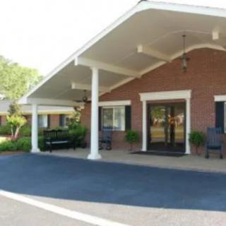 A brick building with a covered entrance and outdoor seating.