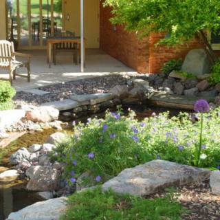 A serene garden with a small pond and seating area.