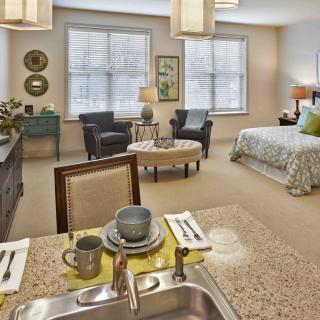 A modern studio apartment featuring a cozy living area and a kitchenette with elegant furnishings.