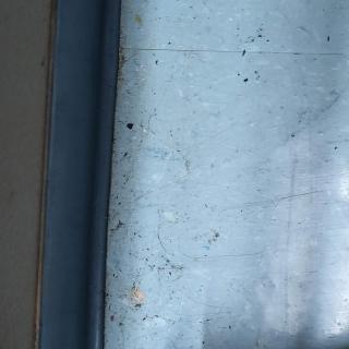 A close-up view of a window with visible textures and light reflections.