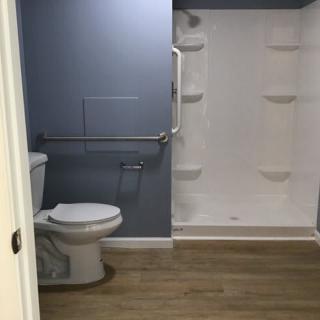 A modern, accessible bathroom with a shower and toilet.