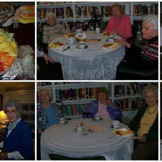 Elderly individuals enjoying a social gathering in a library setting.